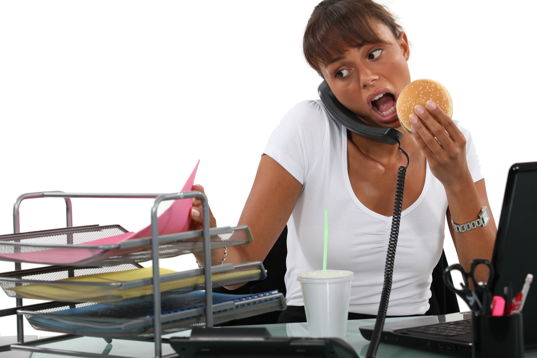 Busy woman eating at her desk